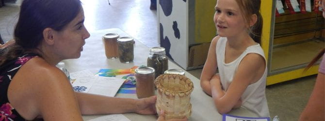 youth speaking with judge about a basket they wove to enter at the fair during project evaluation at the county fair